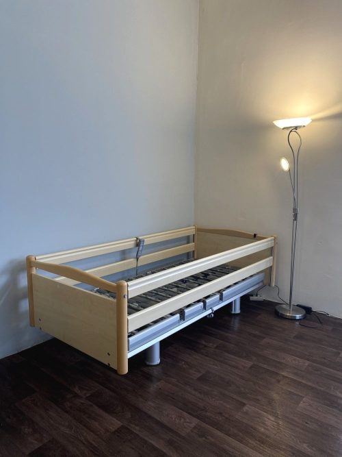 Elektromos betegágy felemelt oldalsó korlátokkal, biztonságot nyújtó kialakítással.