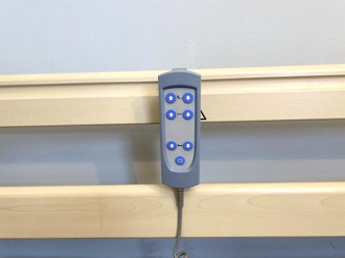 Elektromos betegágy távirányítója, amely a korlátra akasztható a könnyű elérhetőség érdekében.