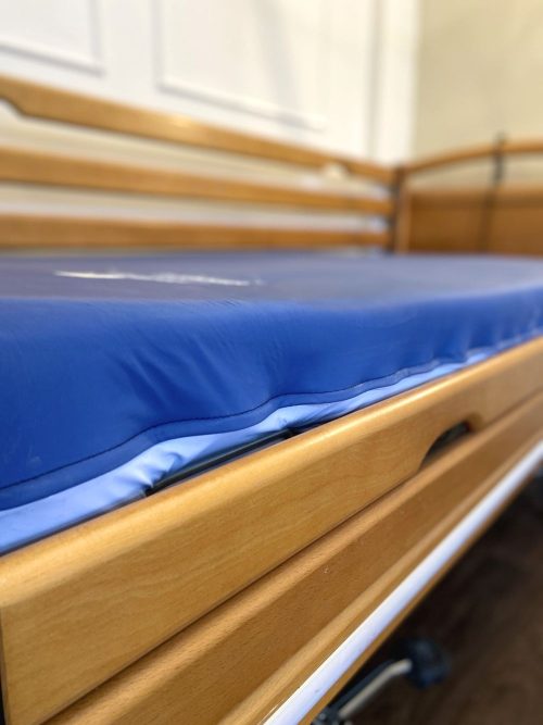 Ápolási ágy csúsztatható oldalkorlátokkal, légáteresztős inkontinenciahuzatos matraccal.