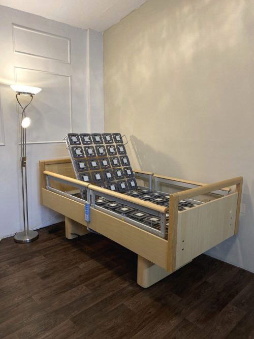 Elektromos betegágy fa borítással és osztott oldalkorláttal, állítható háttámlával.