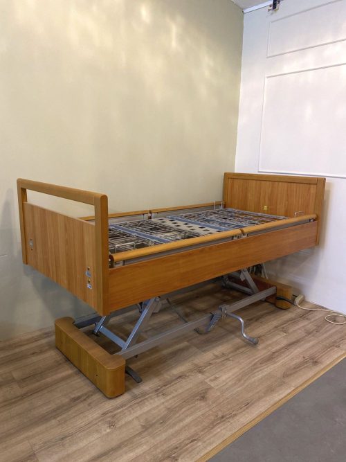 Magasított állásba emelt elektromos betegágy fa borítással.