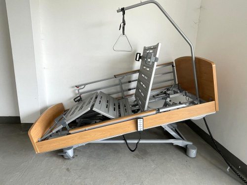 Elektromos betegágy döntött fordított-Trendelenburg pozícióban, állítható háttámlával és lábtámasszal, teleszkópos oldalkorlátokkal és kapaszkodóval a beteg mozgásának támogatására.