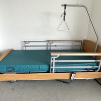 Elektromos betegágy teleszkópos oldalkorlátokkal, kapaszkodóval és vastag matraccal.