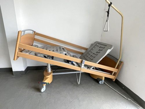 Használt ápolási betegágy Trendelenburg pozícióban, megemelt fejtámlával és kapaszkodóval.