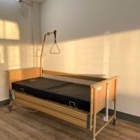 Használt elektromos betegágy otthoni ápoláshoz, fa oldalkerettel és kapaszkodóval