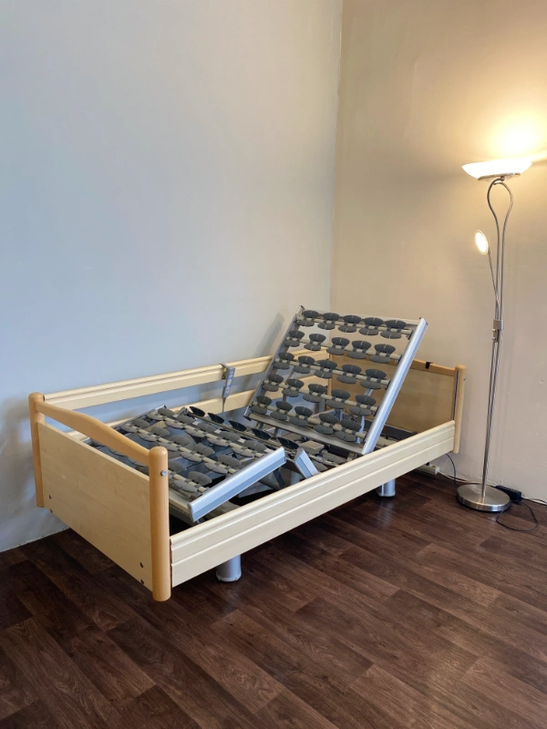 Betegágy emelhető háttámlával és lábtámasszal, beállított pozícióban.